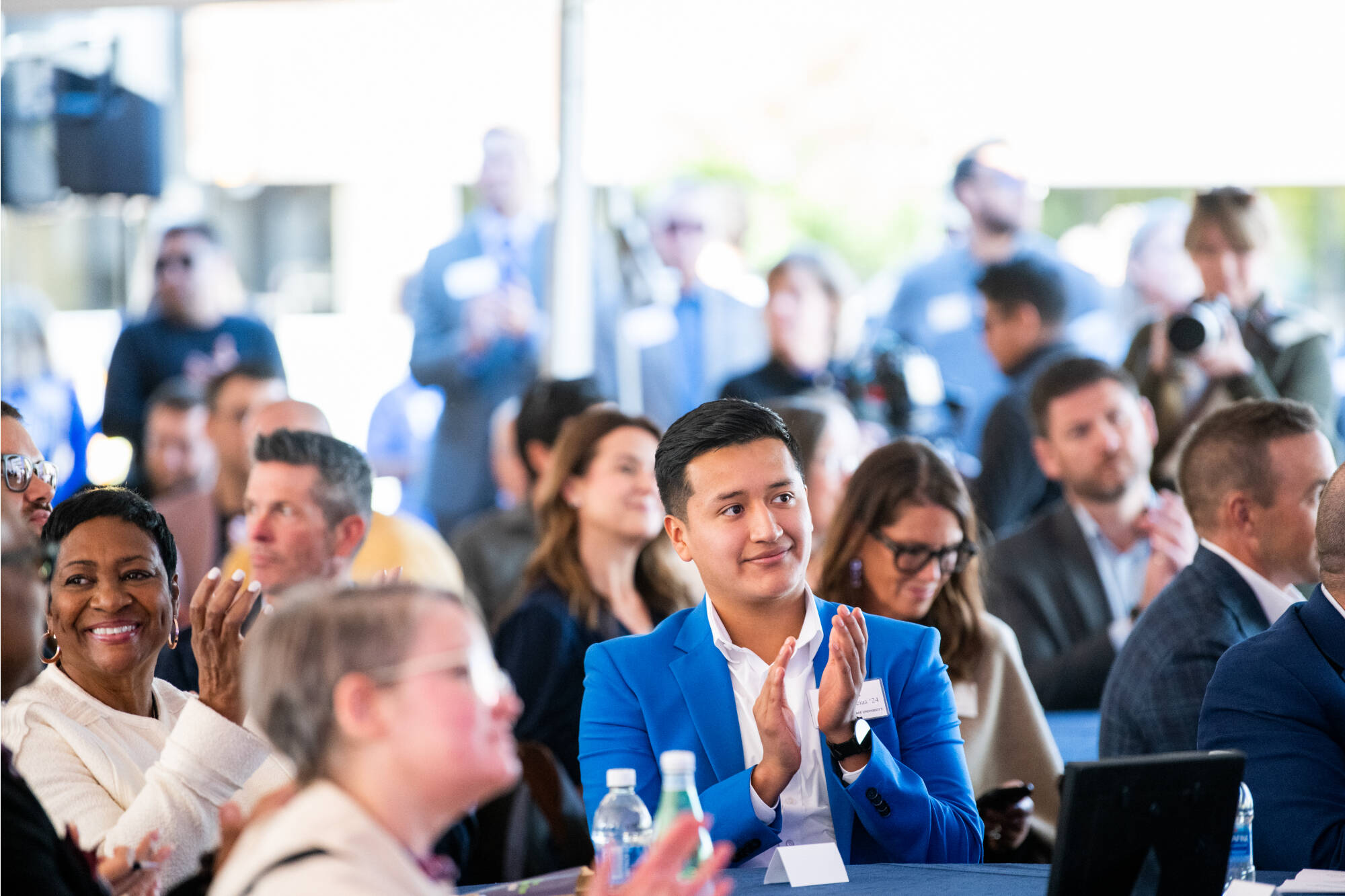 Guests, students and faculty seated and clapping at a GVSU Event.